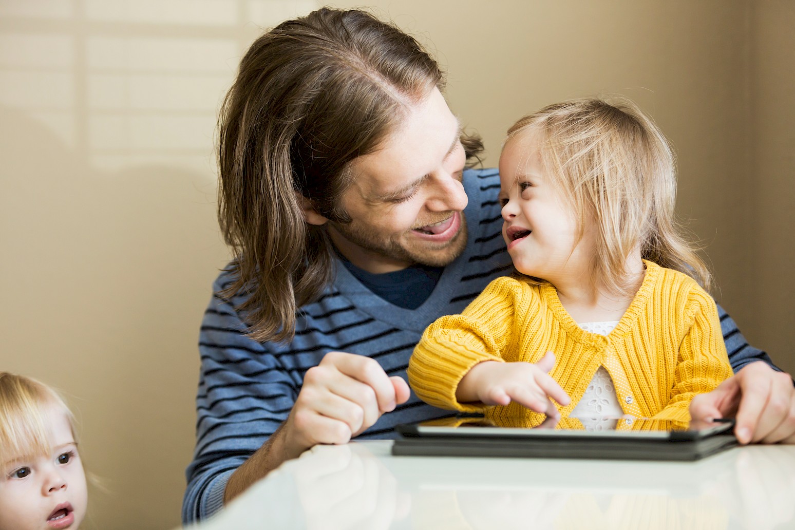 Child and male care worker using a tablet together