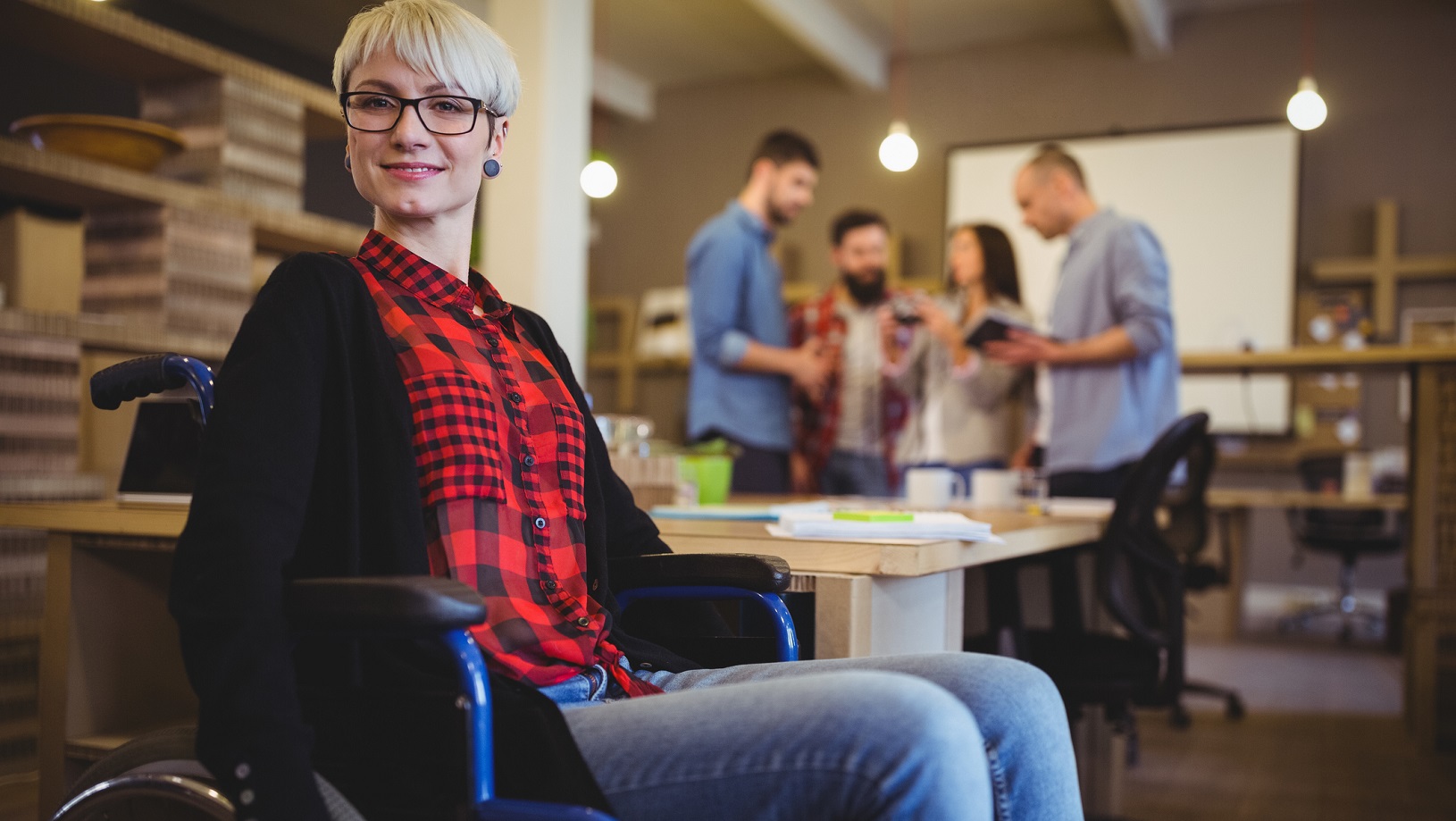 Woman in a wheelchair in an office.