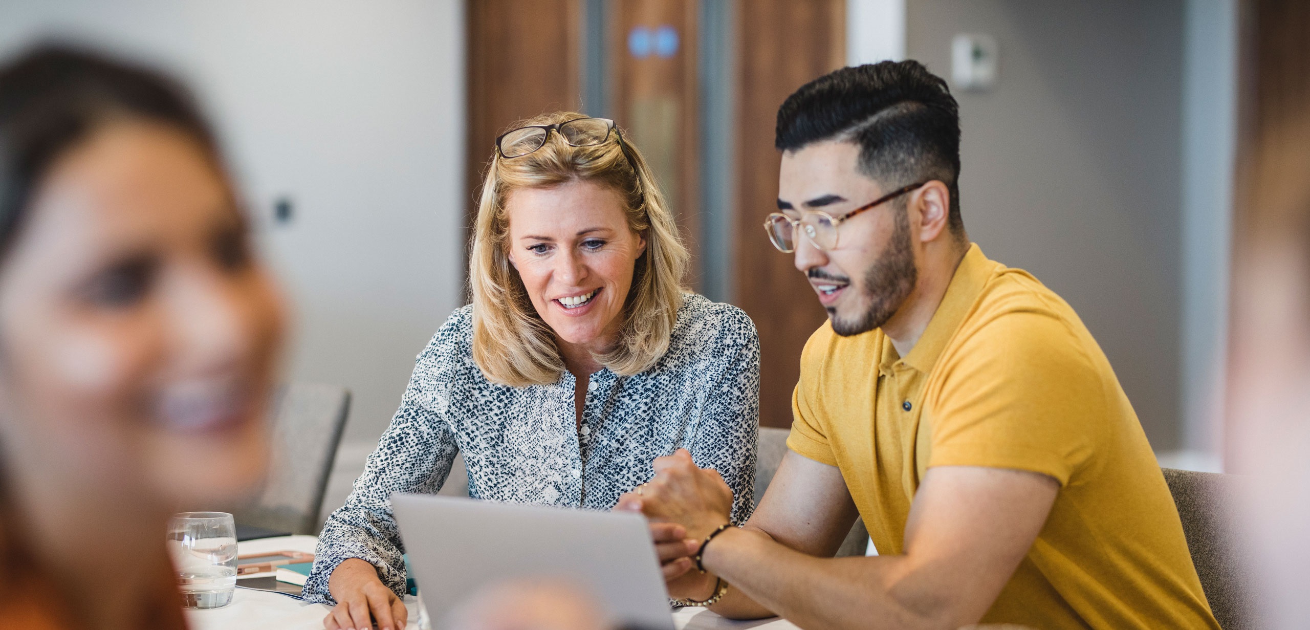 A man and woman working together at a computer